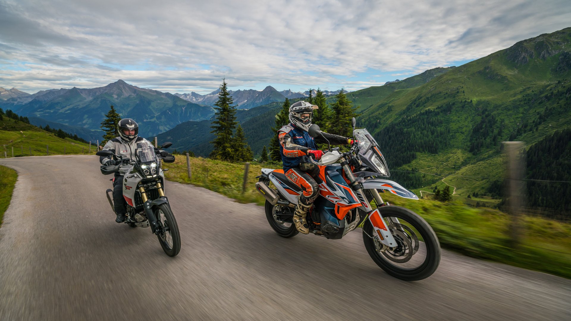 Zwei Motorradfahrer auf Bergstraße mit Alpenpanorama im Hintergrund (© Moppetfoto.de)